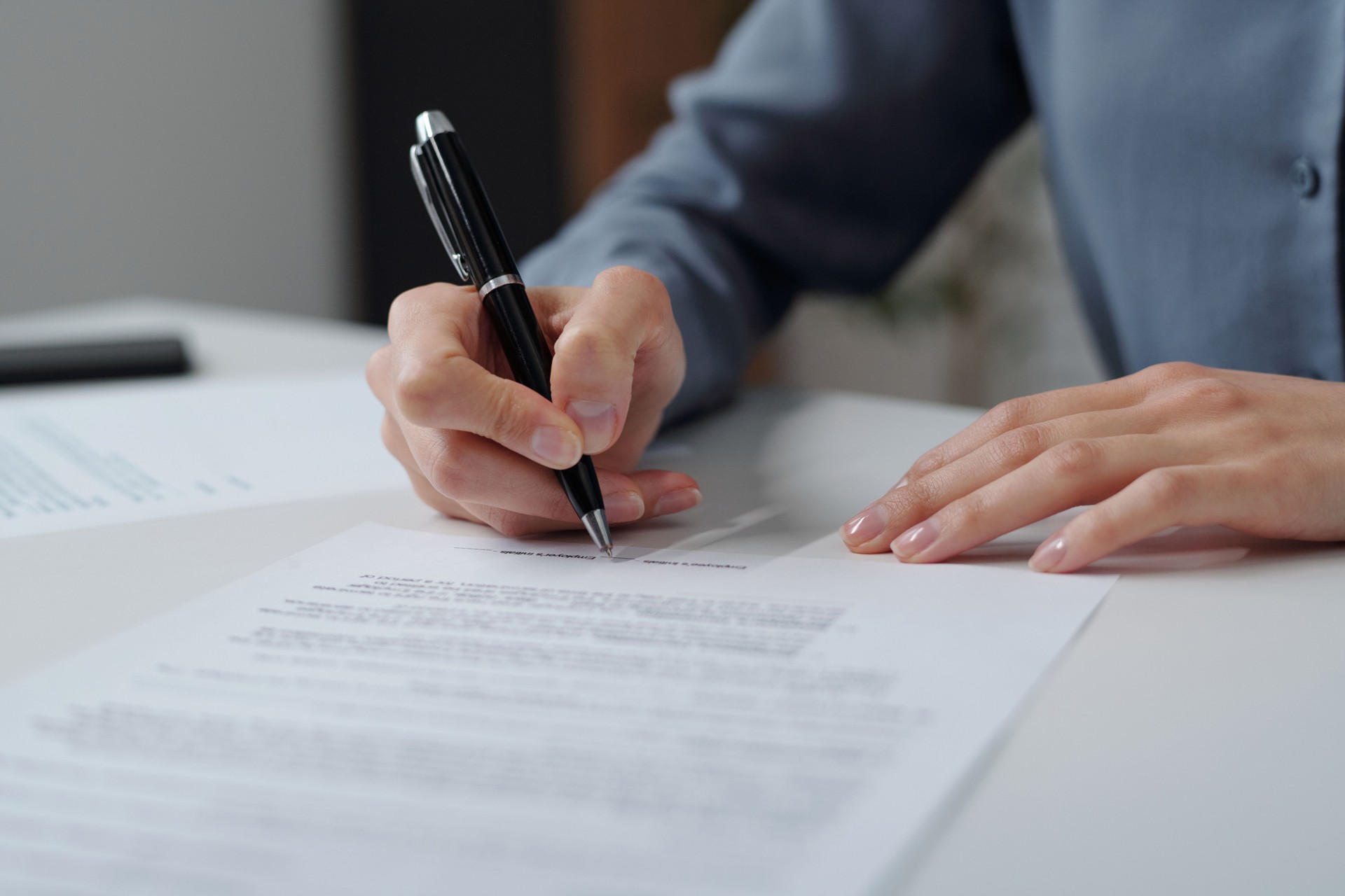 Woman Signing Contract in Office
